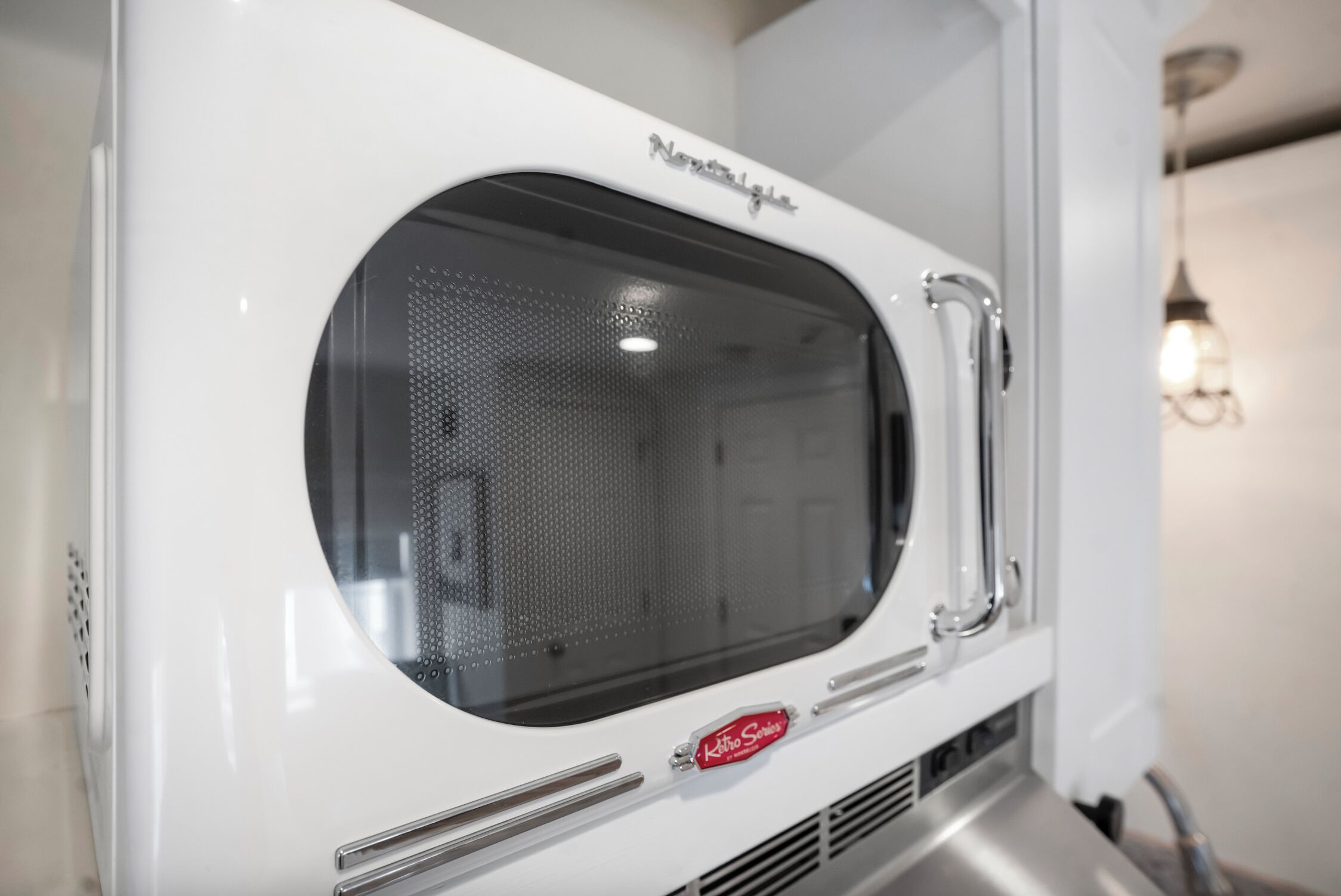 A white microwave oven with a perforated window and a brand name visible.