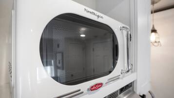 A white microwave oven with a perforated window and a brand name visible.