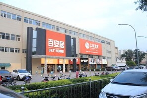 Un immeuble commercial avec une enseigne pour B&T Home et une grande affiche pour une entreprise locale.