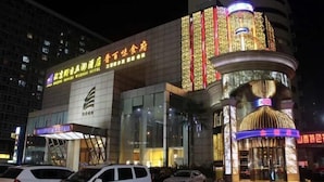 A hotel with a modern facade, large glass windows, and a prominent entrance with a decorative canopy. - Tomorrow Wuzhou Hotel (Beijing West Railway Station Lize Business District) (Beijing)