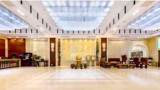 A spacious lobby with a reception desk, seating area, and a large decorative wall. - Tomorrow Wuzhou Hotel (Beijing West Railway Station Lize Business District) (Beijing)