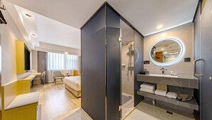 A modern hotel room with a separate living area, a large mirror, a shower, and a neatly organized vanity. - Tomorrow Wuzhou Hotel (Beijing West Railway Station Lize Business District) (Beijing)
