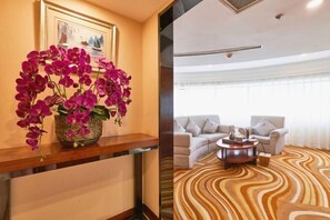 A hotel room with a wooden console table, a framed picture on the wall, a sofa set, and a patterned carpet. - Tomorrow Wuzhou Hotel (Beijing West Railway Station Lize Business District) (Beijing)