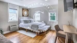 Une chambre à coucher avec un lit, une chaise, une table et un téléviseur.