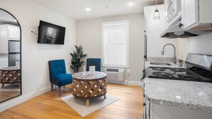 Una cocina moderna con estufa integrada, una mesa de comedor redonda y sillas azules.