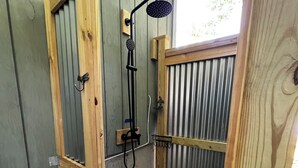 A wooden outdoor shower enclosure with a showerhead and a towel rack. - Lake Cottage - Put your Feet up and Relax! (Moultonborough)