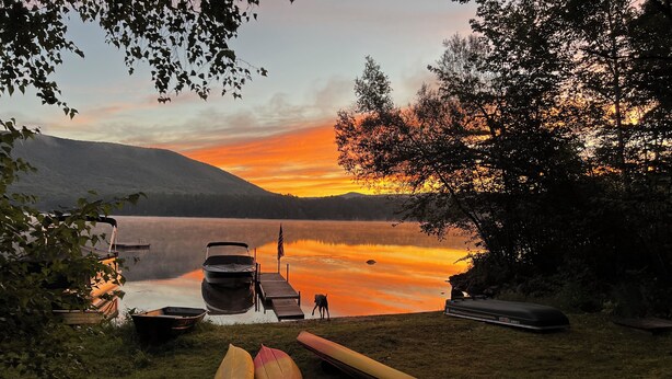 A lakeside view with a dock, boats, and canoes. - Lake Cottage - Put your Feet up and Relax! (Moultonborough)