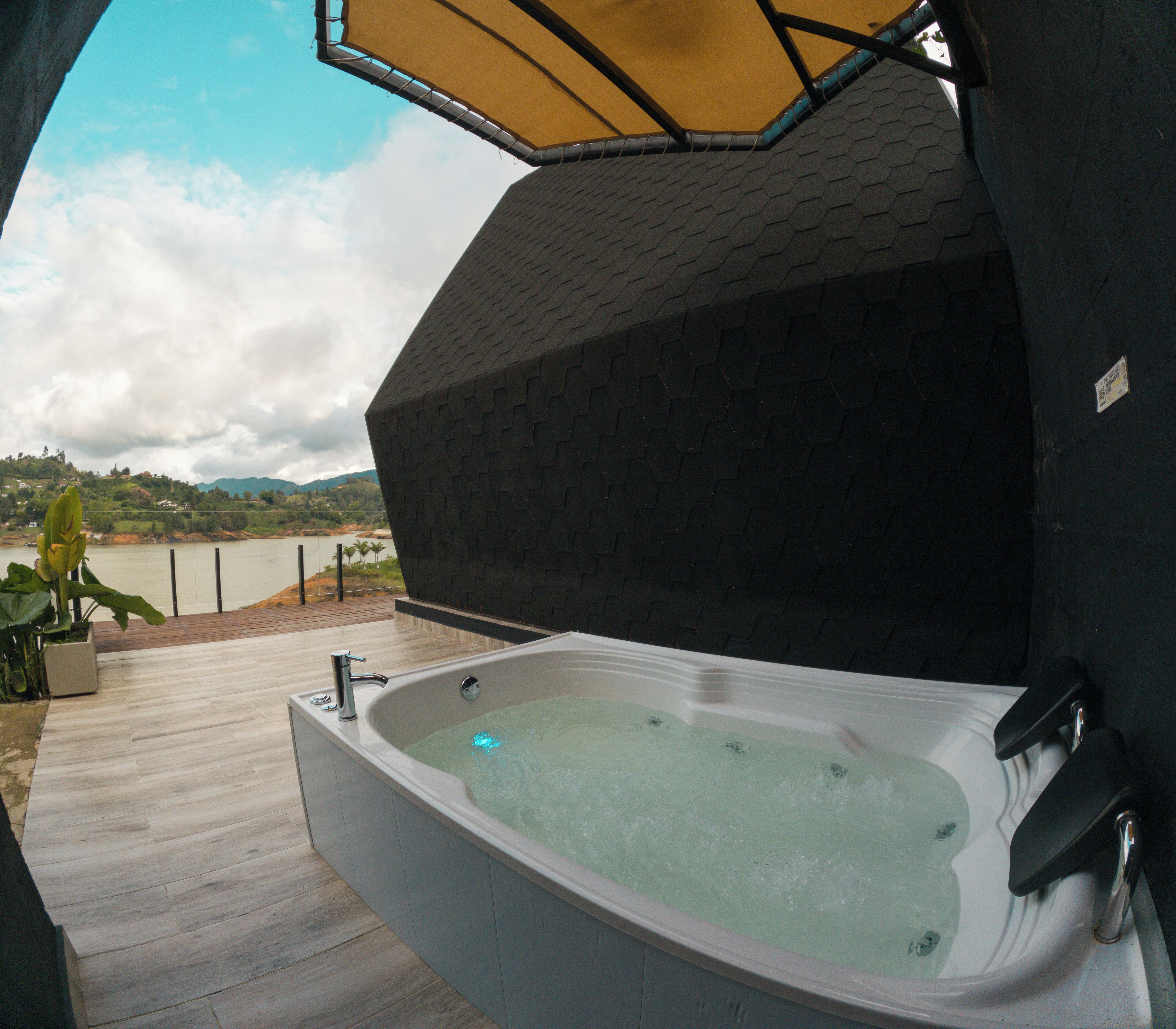 A hot tub with a view of a lake and mountains.