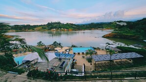 A resort with a pool area, sun loungers, and umbrellas. - Viajero Guatapé Hostel & Lake Club (El Peñol)