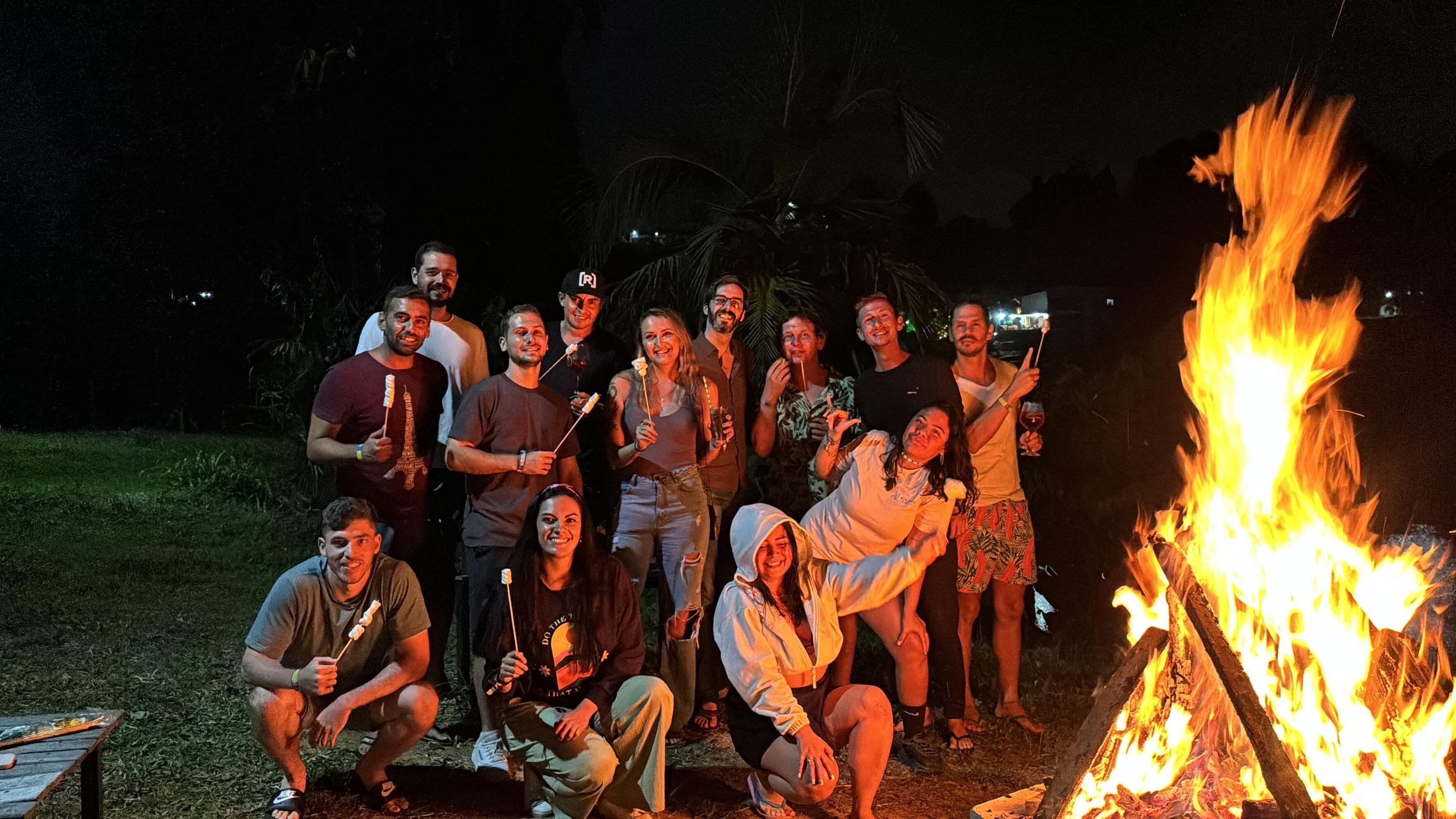 Un grupo de personas reunidas alrededor de una fogata por la noche.