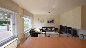 Un salon moderne avec une table à manger, un canapé et un téléviseur.