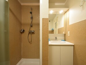 A bathroom with a shower, a sink, and a mirror. - Apartment in De Haan Near the Beach (De Haan)