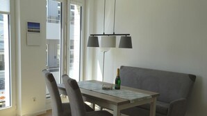 Un espace repas comprenant une table, des chaises, une bouteille de champagne et un canapé.