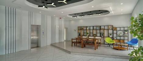 Um hall espaçoso com piso de mármore, balcão de recepção, área de estar e design de teto moderno.