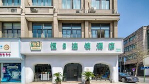 A hotel with a modern facade, multiple entryways, and potted plants at the entrance. - Heng 8 Chain Hotel (Tonglu Xuesheng Road) (Tonglu)