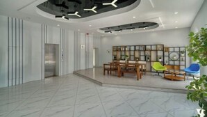 A modern lobby with a marble floor, a wooden dining area, and a wall with a grid of framed pictures. - Heng 8 Chain Hotel (Tonglu Xuesheng Road) (Tonglu)