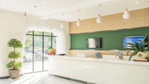 A modern reception area with a green wall, a flat-screen TV, and a reception desk. - Heng 8 Chain Hotel (Tonglu Xuesheng Road) (Tonglu)
