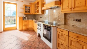 A kitchen with wooden cabinets, a stove, and a sink. - Welcoming Apartment in Stummerberg With Terrace (Stummerberg)
