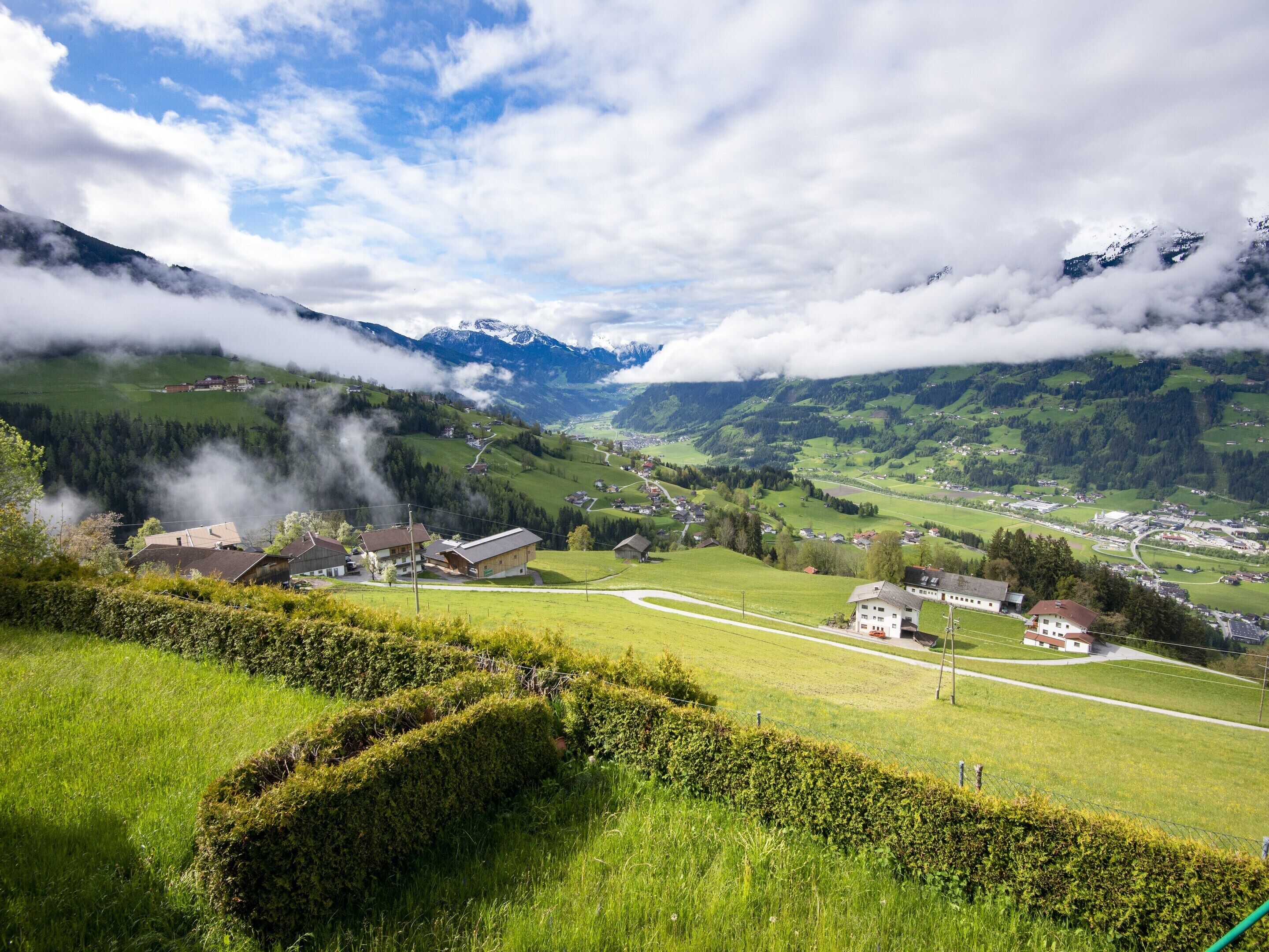 A mountainous landscape with a village, houses, and a road.