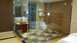 Ein modernes Badezimmer mit einer Duschkabine aus Glas, einem Marmorboden und einer sichtbaren Toilette.