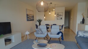 Un salon moderne doté d’un téléviseur, d’un coin salon et d’un espace repas.