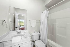 A modern bathroom with a white sink, toilet, and shower area. - Aviation Themed Townhome w/ Waterpark & Game Room - Pet Friendly (Kill Devil Hills)