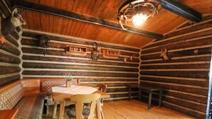 A log cabin interior with a wooden bench, a table, and chairs. - The Waldhaus Modern Retreat (Willingen)