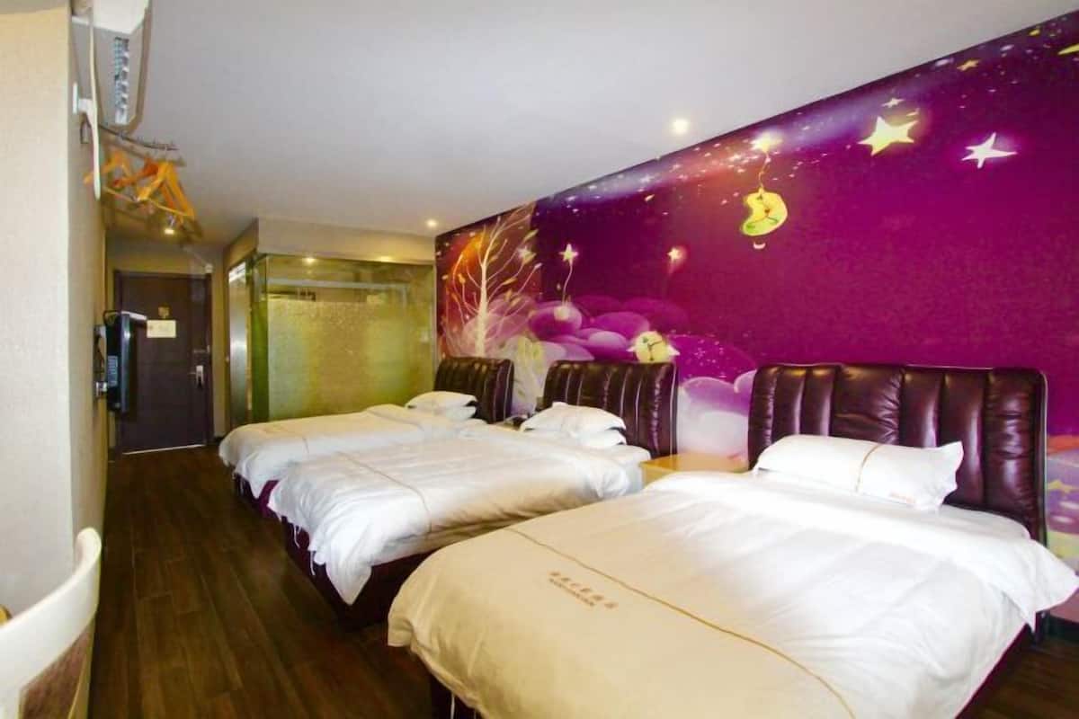 Habitación de hotel con dos camas, un mural en la pared color púrpura y suelo de madera.