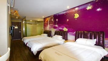 A hotel room with two beds, a purple wall mural, and a wooden floor.