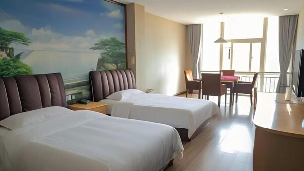 A hotel room with two beds, a desk, a chair, a TV, and a balcony with a view. - Dongyuan Business Hotel (Pinghu)