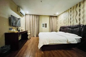 A hotel room with a bed, a desk, a TV, and curtains. - Dongyuan Business Hotel (Pinghu)