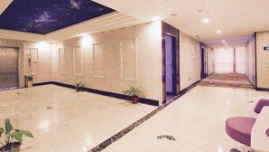 A hotel lobby with a high ceiling, a starry sky mural, a marble floor, and a long corridor leading to a room. - Dongyuan Business Hotel (Pinghu)
