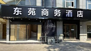 A hotel entrance with a signboard displaying the name. - Dongyuan Business Hotel (Pinghu)