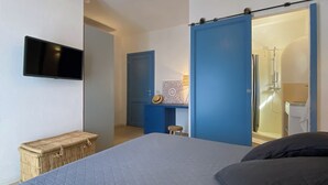 A bedroom with a large bed, a television mounted on the wall, a wardrobe, and a bathroom with a shower. - Apt. Azure, central, parking, top for 6 (San Pantaleo)