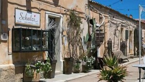 A building with a sign reading "Schatz". - Apt. Azure, central, parking, top for 6 (San Pantaleo)