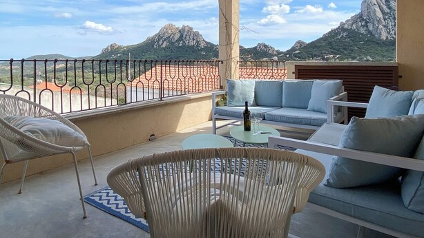 A balcony with wicker chairs, a sofa, and a table. - Apt. Azure, central, parking, top for 6 (San Pantaleo)