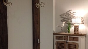 A room with a wooden door, a wall-mounted lamp, and a decorative wall piece. - Watt's Dream Close to the Beach (Büsum)