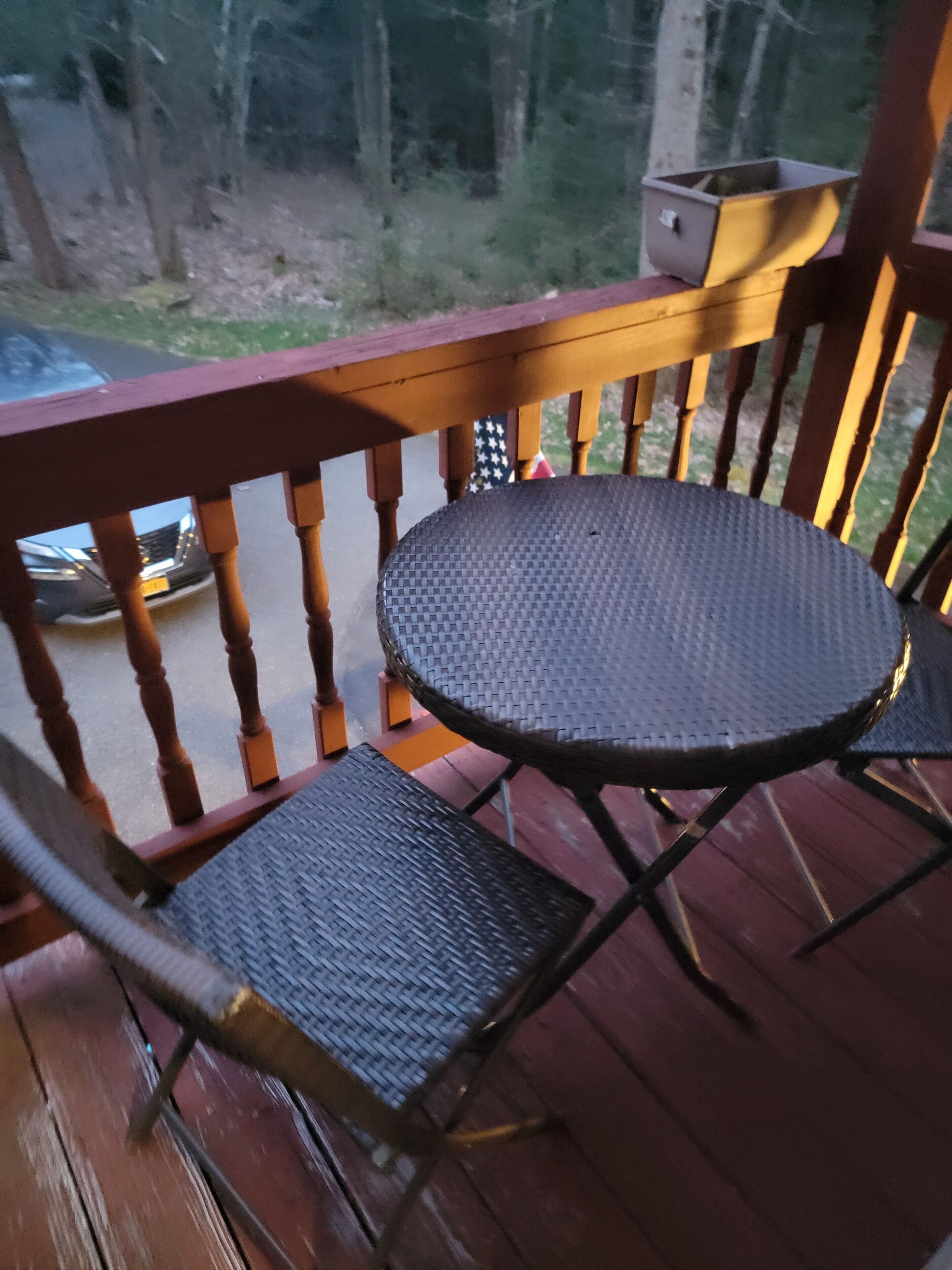 A wooden deck with a round table and two chairs.
