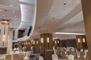 A multi-level hotel conference room with tiered seating, ambient lighting, and a modern design. - Zhuangyuan International Hotel (Hanyuan)