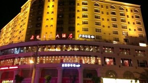 Un hôtel à plusieurs étages, doté d’une enseigne lumineuse et d’une entrée imposante.