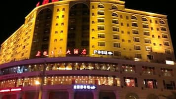 A multi-story hotel with illuminated signage and a prominent entrance.