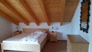 Ein Schlafzimmer mit einem hölzernen Bett, Nachttischen und einer Kommode.
