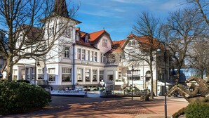 A historic building with a prominent tower and a café on the ground floor.