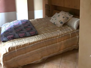 A bed with a striped bedspread and a patterned pillow. - Cosy Apartment in Bad Harzburg With Garden (Bad Harzburg)