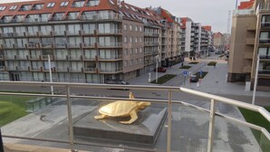 A building with multiple balconies and a large golden turtle sculpture on the ground floor. - Apartment in Nieuwpoort With Terrace (Nieuwpoort)