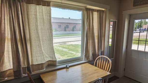 A small room with a window, a table, two chairs, and a door.