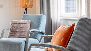 A room with two armchairs, a floor lamp, and a window with curtains. - Holiday Home Near Dunes With Wellness Garden (Den Burg)
