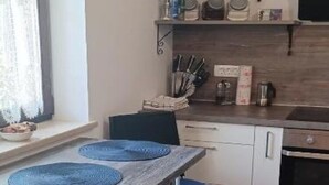 A compact kitchen with a wooden countertop, a built-in oven, and a window with sheer curtains. - Apartment RR - One Bedroom Apartment With Balcony (Lovran)