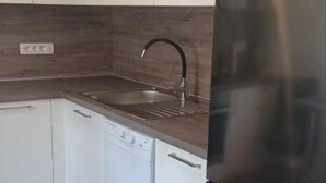 A kitchen with white cabinets, a dishwasher, a stainless steel sink, and a black faucet. - Apartment RR - One Bedroom Apartment With Balcony (Lovran)