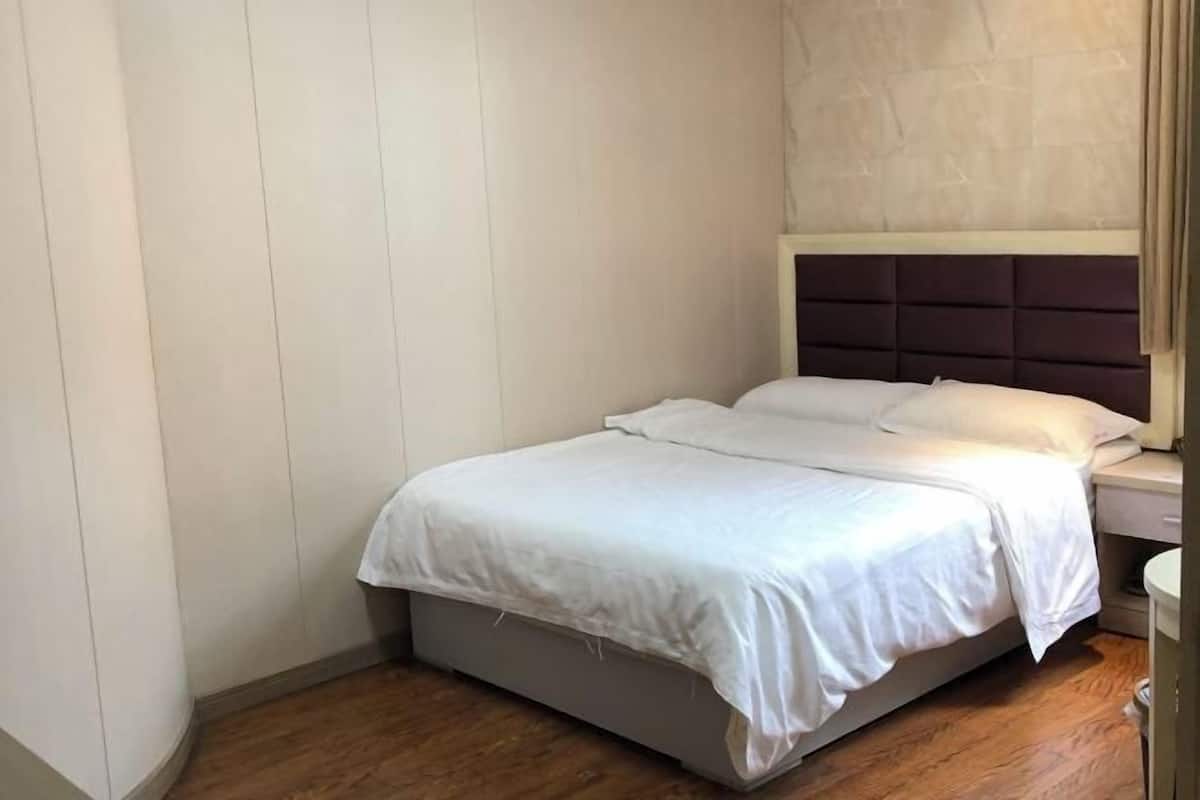 Ein Einzelbett mit Kopfteil, Nachttisch und Holzboden.